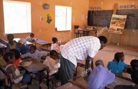 un-enseignant-daider-les-eleves-dans-une-salle-de-classe-de-tereli-pays-dogon-mali-a63gpj