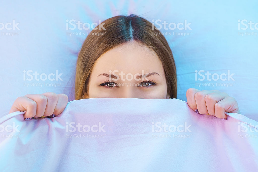 Shy girl hiding in bed